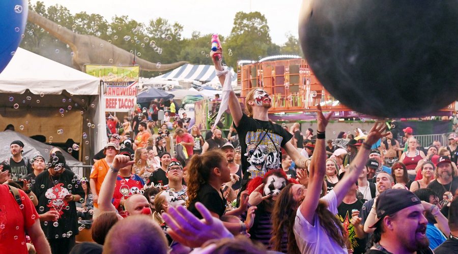 Fun loving and dancing juggalos enjoy the bubble blowing scene during a daylight concert at the 2022 Gathering of the Jaggalos music festival